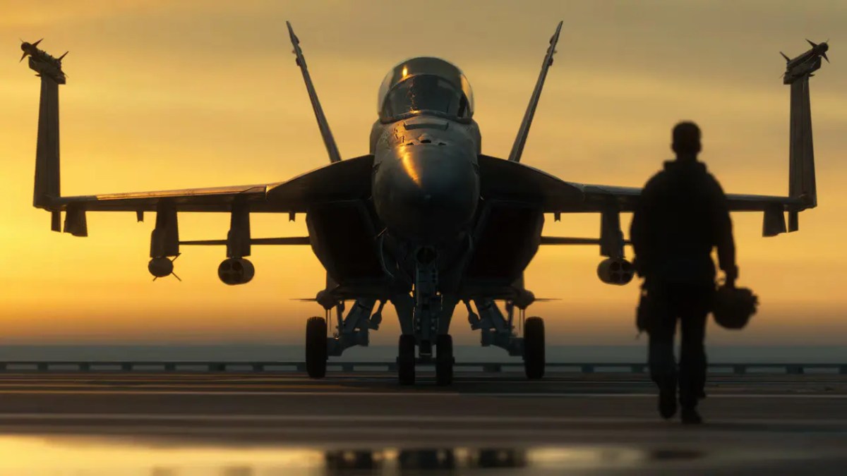 Silhouette of a pilot walking past a fighter jet on an aircraft carrier runway at sunset from the Battlefield 6 update 1.4.2.0 patch notes.